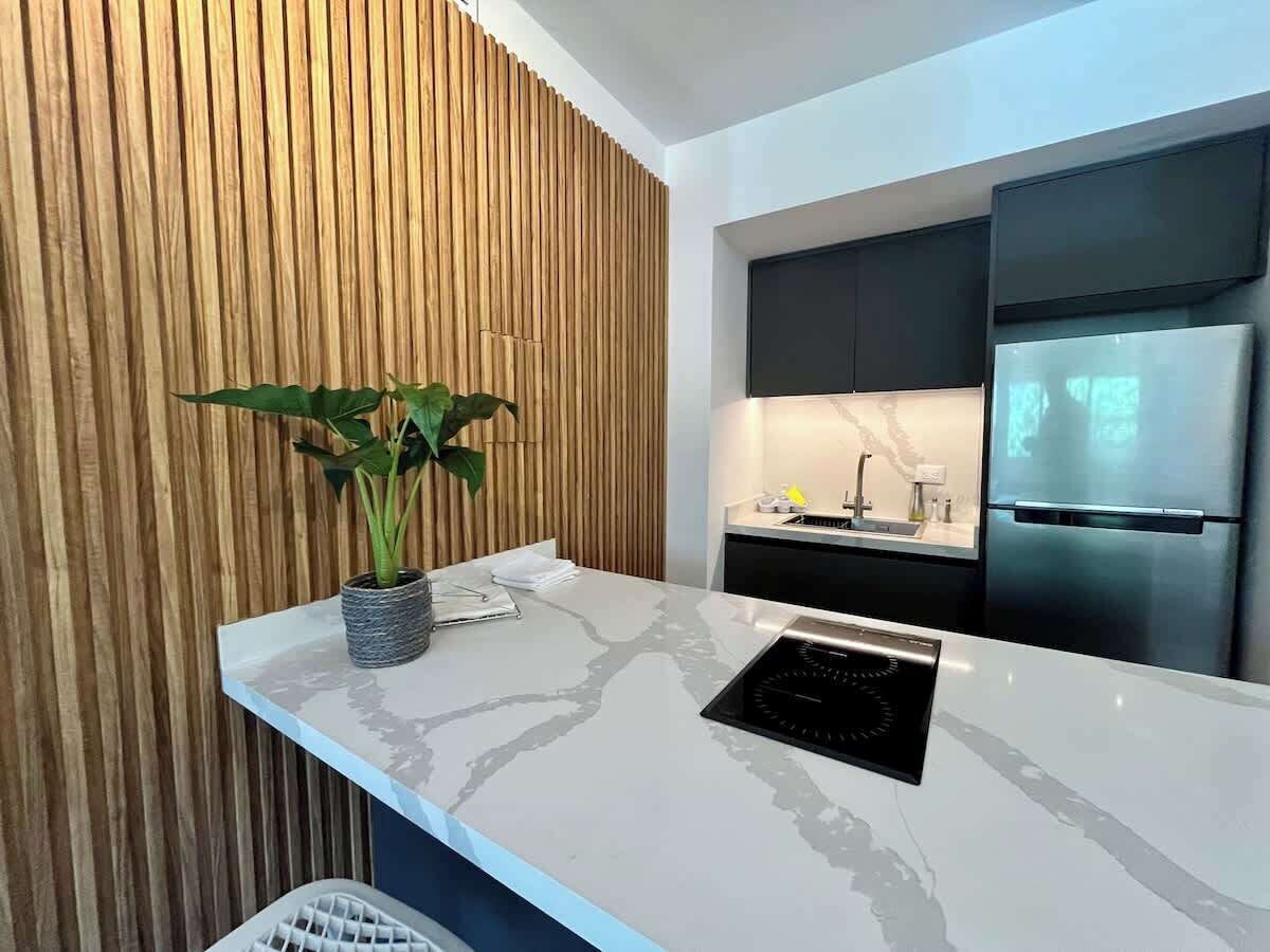 Une cuisine moderne équipée d’une cuisinière intégrée, d’un évier et d’un réfrigérateur.