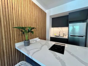 Eine moderne Küche mit Einbauherd, Spüle und Kühlschrank.