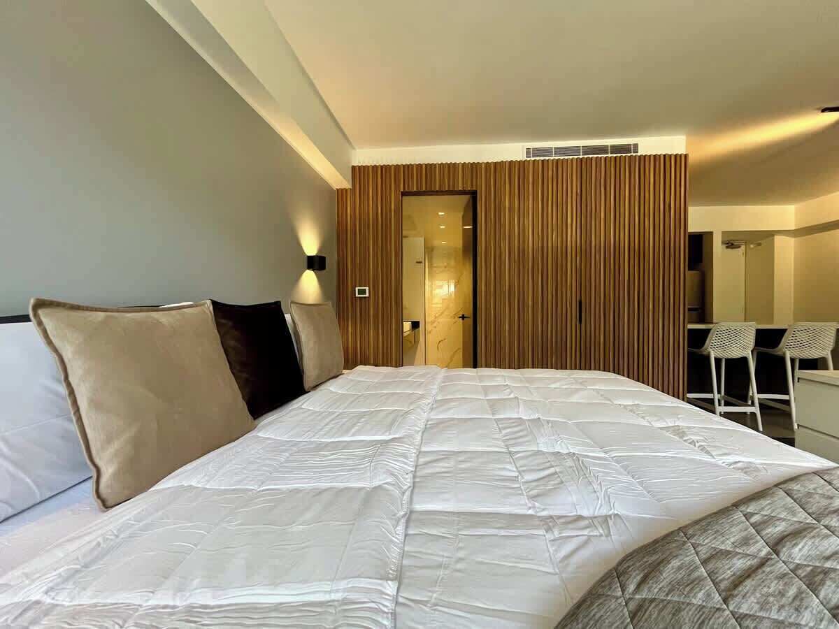 A hotel room with a large bed, a desk, and a chair.