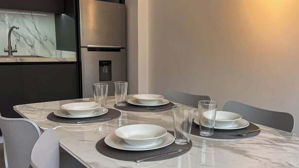 Un tavolo da pranzo apparecchiato con piatti, bicchieri e un dispenser d'acqua.