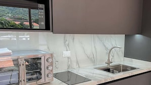 Una cucina moderna con forno a incasso, lavello e finestra vista edifici.