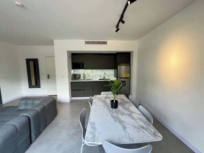 A modern living space with a dining area, a kitchen, and a seating area. - PH Altamira: Vistas Ávila & Terraza Panorámica (Caracas)