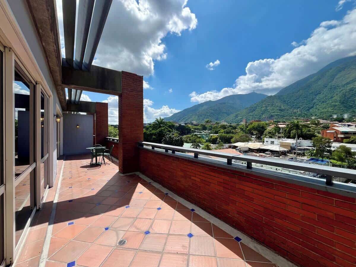 Un balcón con vista a una montaña y un pueblo.