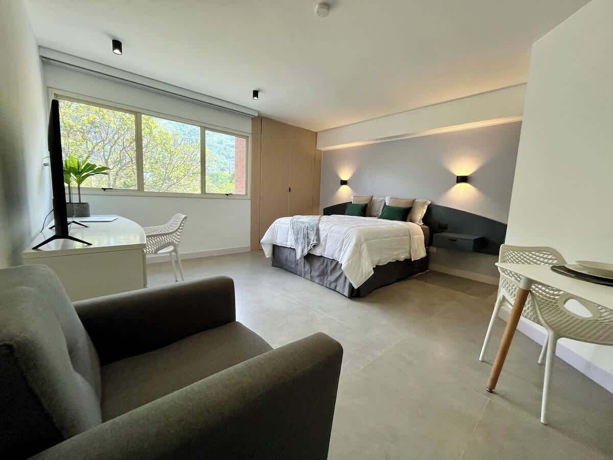 Une chambre à coucher moderne avec un lit, des tables de chevet, une chaise et un bureau.