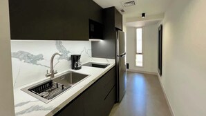 A modern kitchen with a built-in sink, a coffee maker, and a refrigerator. - Romantic Altamira Apt: Fast WiFi & Privacy (Caracas)