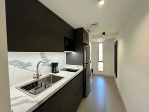 A modern kitchen with a built-in sink, a coffee maker, and a refrigerator. - Romantic Altamira Apt: Fast WiFi & Privacy (Caracas)