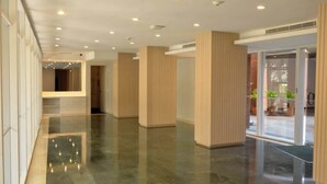 A spacious lobby with a polished floor, wooden paneling, and a glass entrance leading outside. - Romantic Altamira Apt: Fast WiFi & Privacy (Caracas)