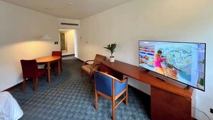 Ett hotellrum med en matplats, en tv och en växt.