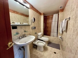 Ein Badezimmer mit Waschbecken, Toilette, Bidet und Dusche.