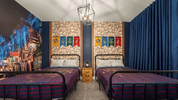 A room with two beds, a stone wall, and a mural of a cityscape. - Davenport Disney Home Private Pool (Davenport)