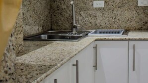 Eine moderne Küche mit weißen Schränken, einer Granitarbeitsplatte und Edelstahlgeräten.