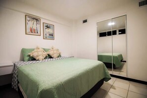 Une chambre à coucher avec un lit, une armoire et deux tableaux encadrés accrochés au mur.