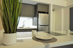 A modern kitchen with a stainless steel refrigerator, a sink, and a potted plant on the counter. - Remodelado y Cómodo: Internet Rápido + Zona Top (Caracas)