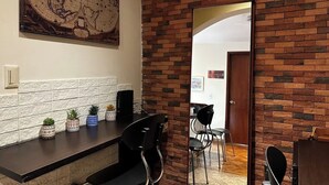 Una cocina moderna con pared de ladrillo, un mapa grande y un área de comedor con sillas y una mesa.