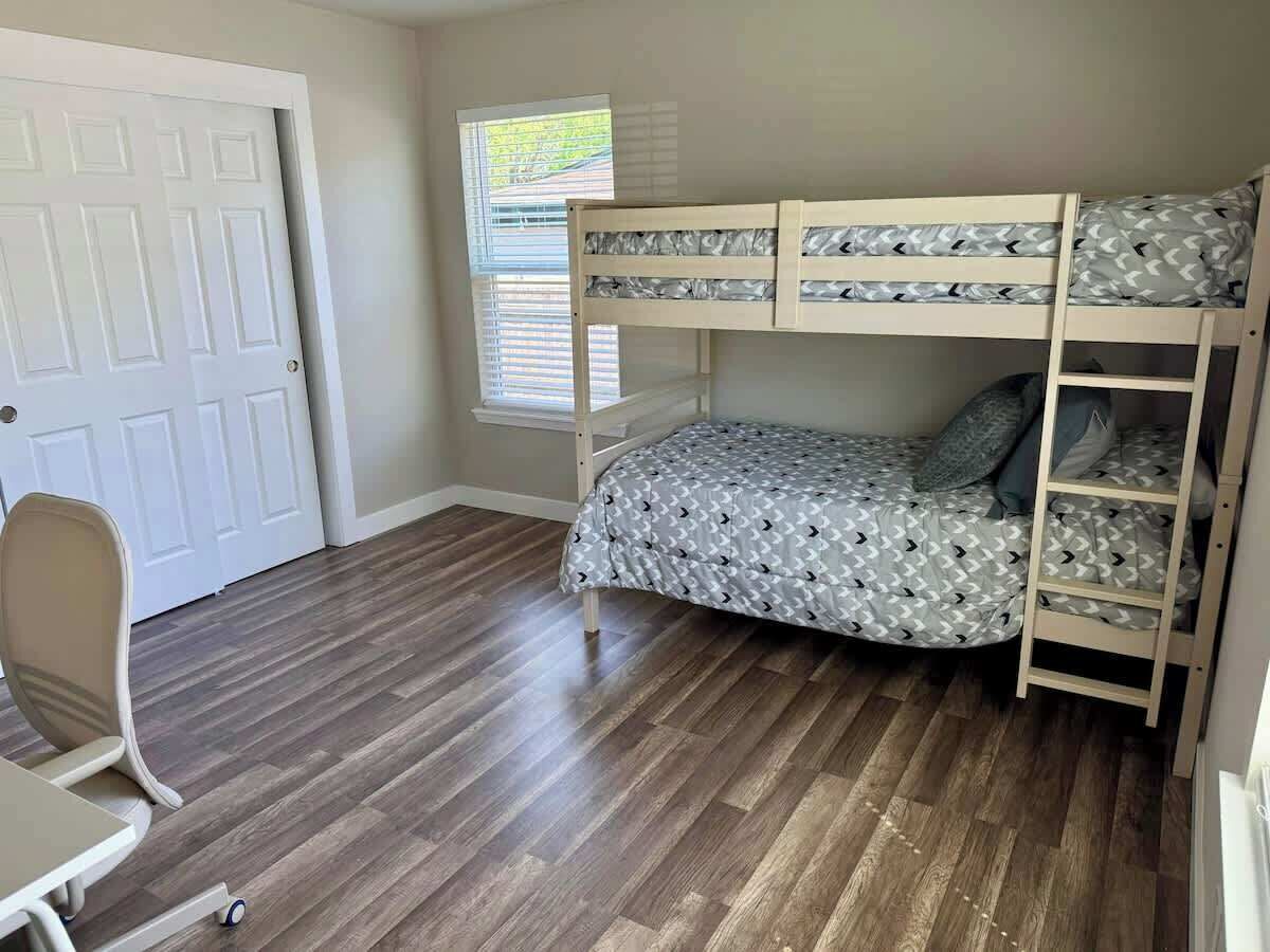 Ein Zimmer mit einem Etagenbett, einem Schreibtisch und einem Stuhl.