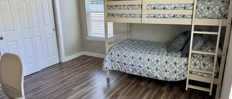 Una habitación con literas, un escritorio y una silla.