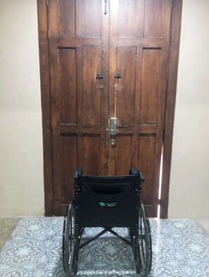 A wheelchair in front of a wooden door. - La María House: lux, comfort, and pool (Merida)