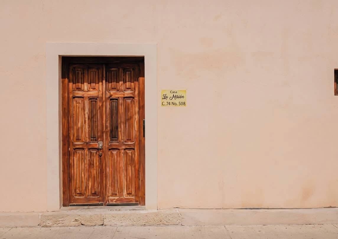 A double wooden door with a sign above it indicating 'Casa Le Mairie C. 74 No. 508'.