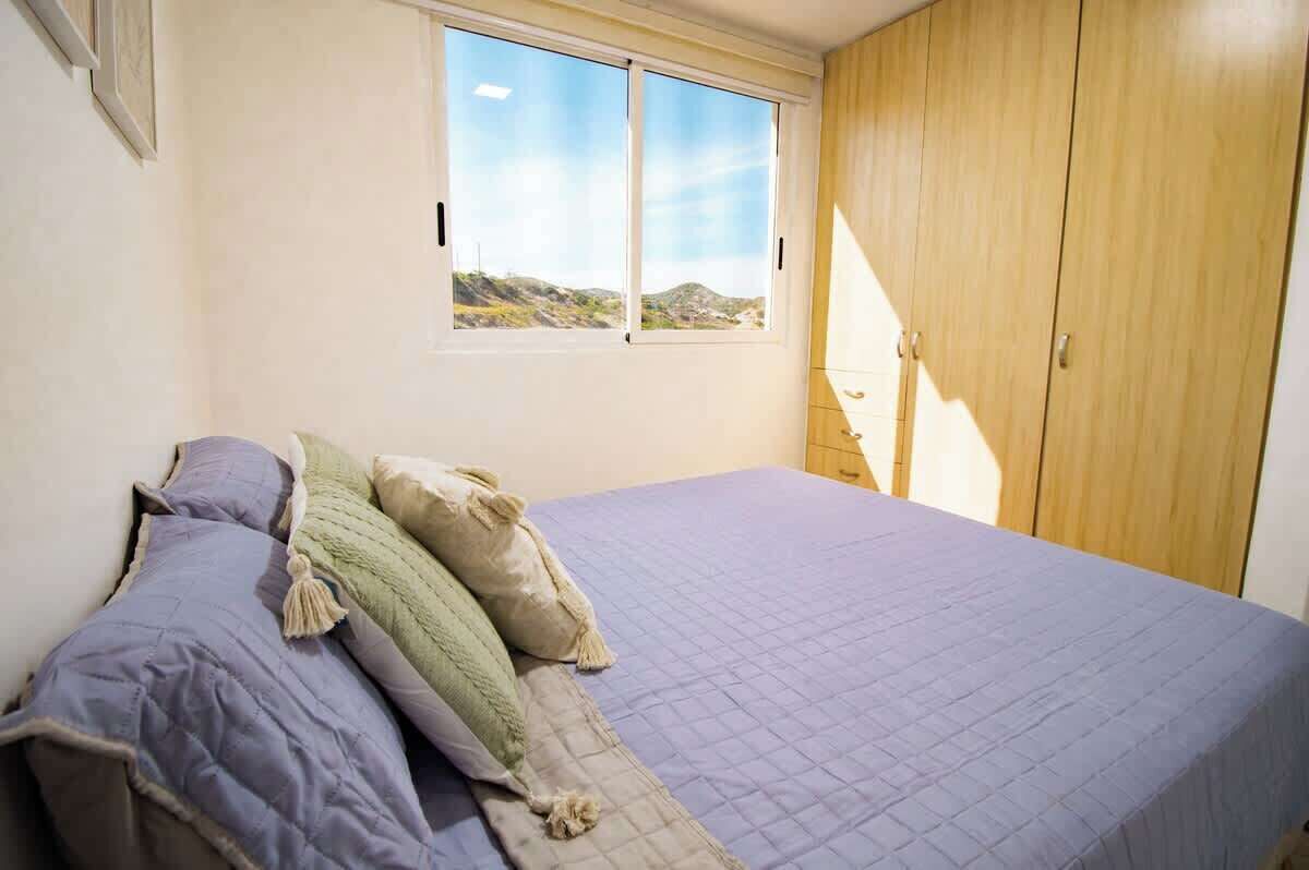 A bedroom with a bed, a window, and a wardrobe.