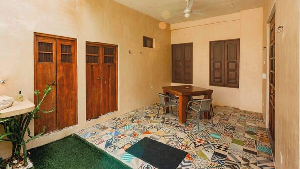 A room with a tiled floor, a ceiling fan, and a wooden table with chairs. - Casa Colonial c/Alberca Privada (Merida)