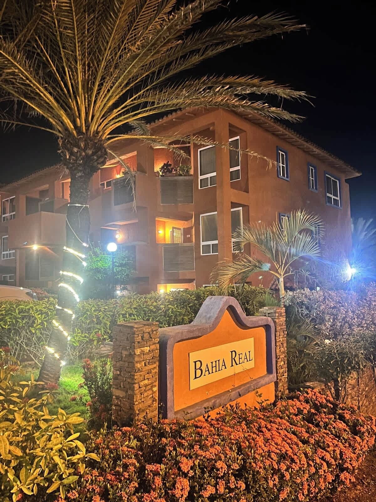 A multi-story building with a sign reading 'Bahia Real' in front.