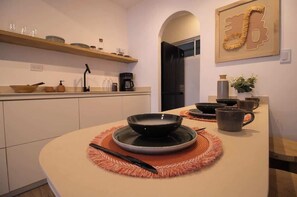 Una cucina moderna con un tavolo da pranzo rotondo, una macchina da caffè e un frigorifero.