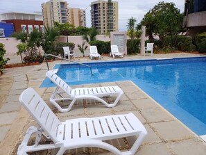 A swimming pool with lounge chairs and a tiled deck. - Tus vacaciones perfectas a 360° (Porlamar Mariño)