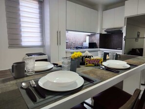 A modern kitchen with a central island, equipped with a toaster, a coffee maker, and a fruit bowl. - Tus vacaciones perfectas a 360° (Porlamar Mariño)
