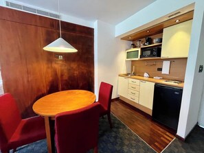 A compact kitchen with a microwave, stove, and dishwasher. - Encanto Clásico en Altamira: Piso 4 con Balcón (Caracas)