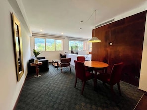 Un intérieur moderne comprenant un coin repas, un canapé, une petite table et une grande fenêtre donnant sur un paysage agréable.