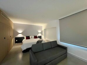 A modern bedroom with a bed, a sofa, and a large window. - Elegante, moderno y práctico en Caracas (Caracas)