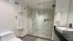 Et moderne badeværelse med toilet, bruser og vask.