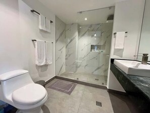 Ein modernes Badezimmer mit Toilette, Dusche und Waschbecken.