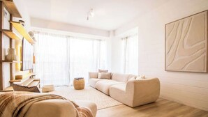 A modern living room with a sofa, a coffee table, and a bookshelf.