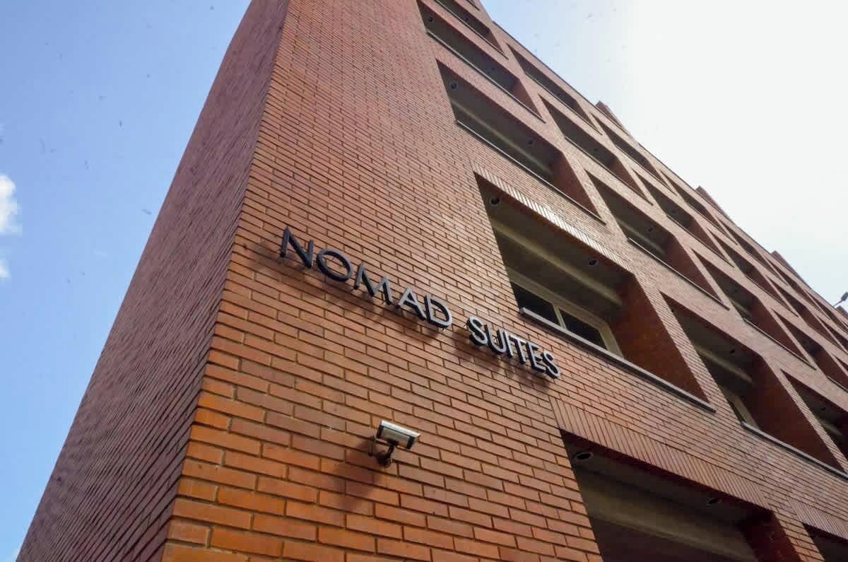 Un edificio con el letrero 'NOMAD SUITES', que indica un hotel o alojamiento.