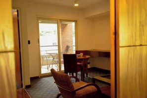 A room with a sliding glass door leading to an outdoor area with a table and chairs.