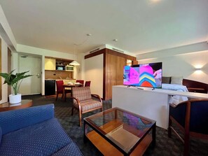 A hotel room with a seating area, a TV, a kitchenette, and a dining area. - Altamira Apt w/ Balcony & High-Speed WiFi (Caracas)