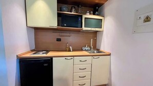 Uma cozinha compacta com micro-ondas, pia e lava-louças.