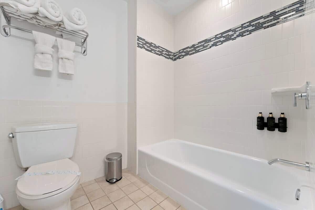 Une salle de bain équipée d’un WC, d’un lavabo, d’une baignoire et d’un porte-serviettes avec des serviettes.
