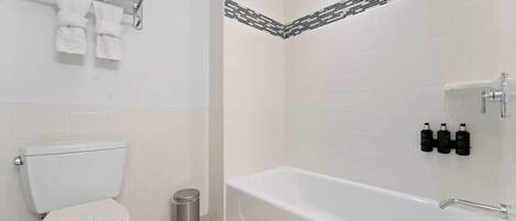 Une salle de bain équipée d’un WC, d’un lavabo, d’une baignoire et d’un porte-serviettes avec des serviettes.