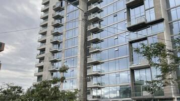 Un edificio de gran altura con varios balcones y fachada de vidrio.