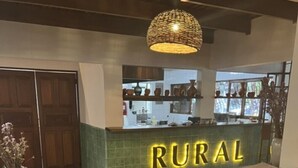 Ein Empfangsbereich mit einer Theke, auf der 'RURAL' steht, und einer hängenden Leuchte.
