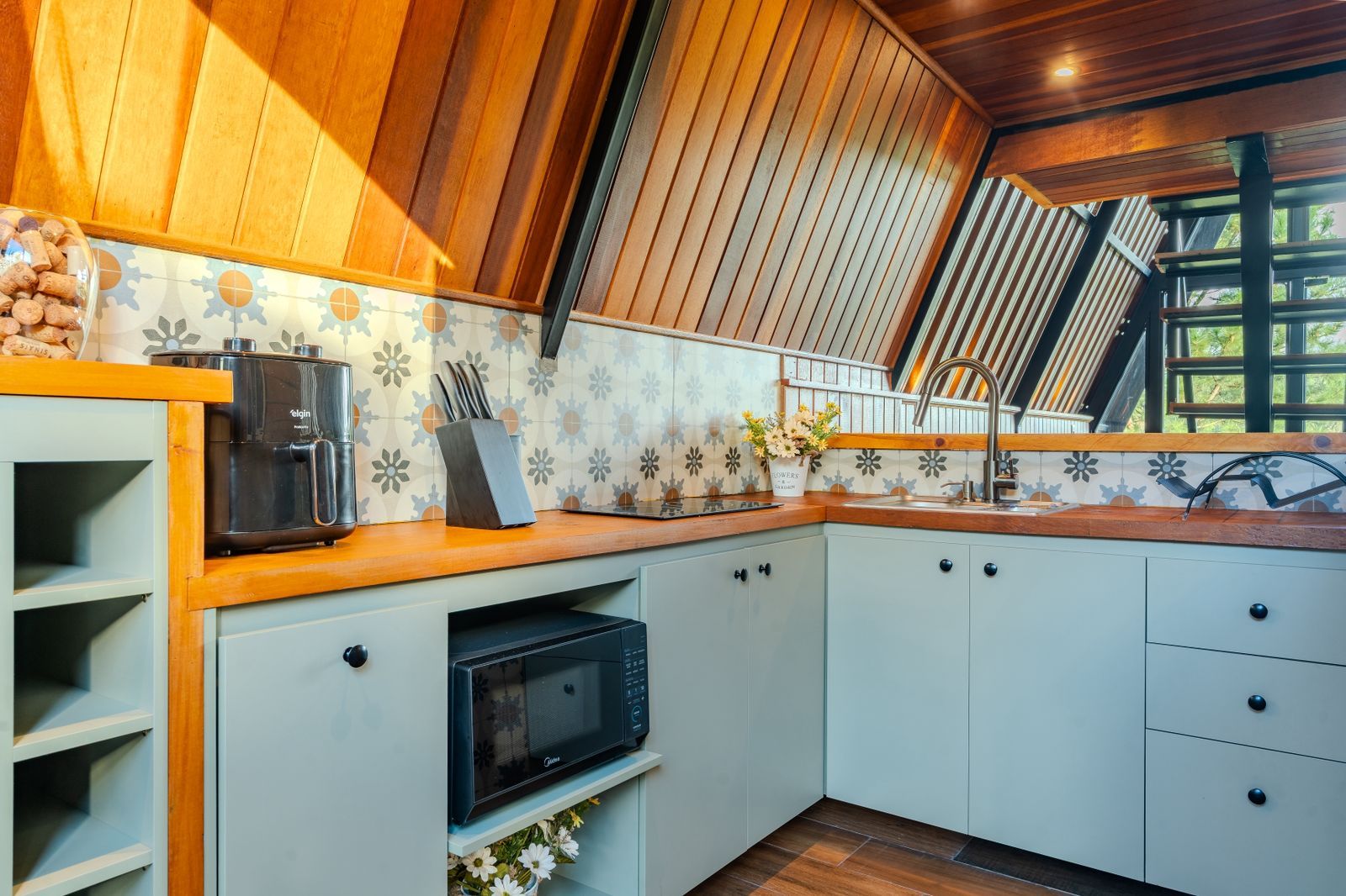 A kitchen with a built-in oven, a coffee maker, and a microwave.