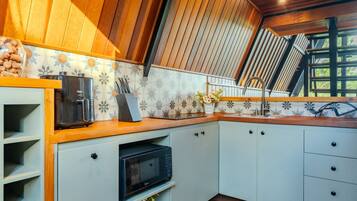A kitchen with a built-in oven, a coffee maker, and a microwave.
