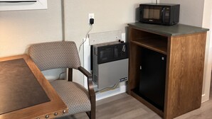 A compact kitchenette with a microwave, a chair, and a table. - Renovated Queen Room on Main Street in Longmont (Longmont)