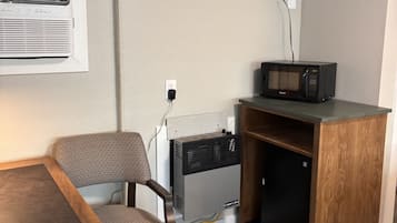 Une petite cuisine équipée d’un micro-ondes, d’une chaise et d’une table.