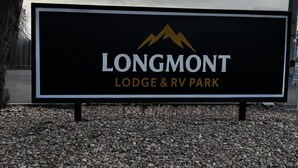 A sign for Longmont Lodge & RV Park. - Renovated Queen Room on Main Street in Longmont (Longmont)
