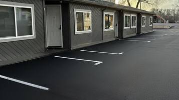 Une rangée de bâtiments d’un seul étage, avec un parking devant.