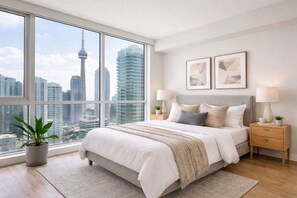 Une chambre moderne avec une grande fenêtre, un lit, deux tables de chevet et une vue sur le paysage urbain.