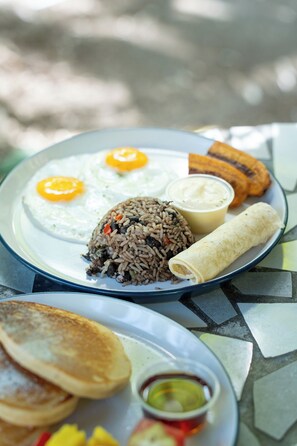 Une assiette de riz frit, d’œufs, d’une tortilla et de bananes plantains.
